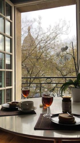 - une table avec deux verres de vin et une fenêtre dans l'établissement One Room Apartment in Paris Montmartre, à Paris