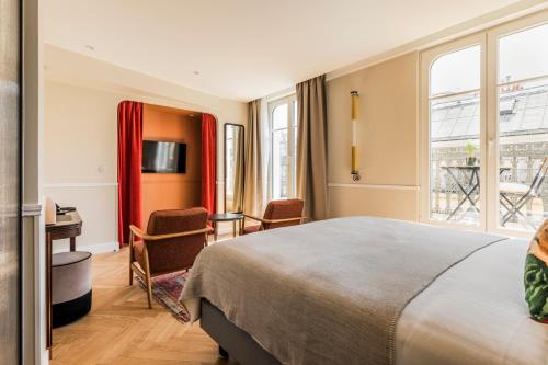 Habitación de hotel con cama y escritorio en Hôtel Chamar en París