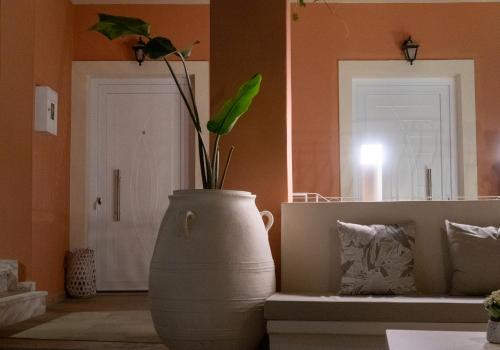 a large white vase with a plant in a room at Cristina Apartments in Gaios