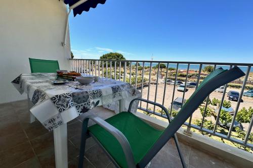 une table et des chaises sur un balcon avec vue sur l'océan dans l'établissement DOUCEUR DE MEDITERRANÉE - Vue mer Terrasse et parking, au Grau-du-Roi