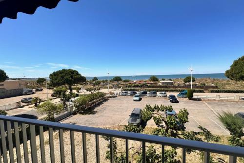 une vue d'un parking depuis un balcon dans l'établissement DOUCEUR DE MEDITERRANÉE - Vue mer Terrasse et parking, au Grau-du-Roi