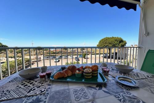 une assiette de nourriture sur une table sur un balcon dans l'établissement DOUCEUR DE MEDITERRANÉE - Vue mer Terrasse et parking, au Grau-du-Roi