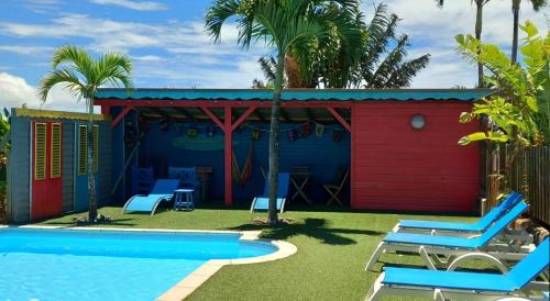 a resort with a pool and a red shed at Piton Bungalows Ecolodges in Deshaies