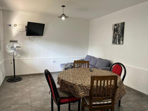 a dining room with a table and a couch at 25 de mayo in Villa Dolores