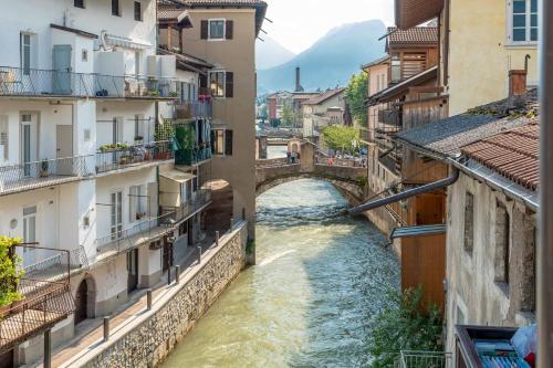 a bridge over a river in a city with buildings at Luxury 2BR w/ River Castle View in Borgo Valsugana in Borgo