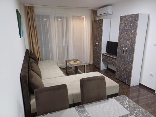 a living room with a couch and a television at Prenoćište SILVER LUX Srebrno Jezero in Veliko Gradište