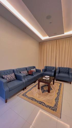 a living room with blue couches and a coffee table at درر السمو للشقق المخدومة in Ad Dawādimī