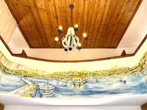 a chandelier hanging from a ceiling with a painting at Casa Piaduli in Faliraki