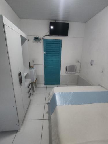 a bathroom with a tub and a blue door at Hospedagens Icapui Mare Blu in Icapuí