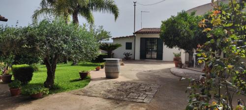 a house with a yard with trees and a driveway at Voscenza Benerica in Vittoria