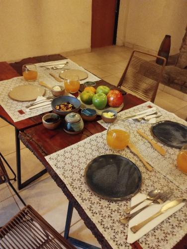 una mesa con platos y tazones de fruta. en La Genoveva Posada entre Viñedos, en Villa Unión