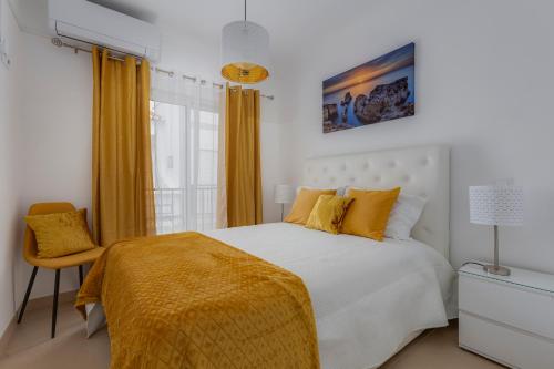 a bedroom with a white bed and a yellow blanket at Chez Oasis Lagos - Charming Central by the Beach in Lagos
