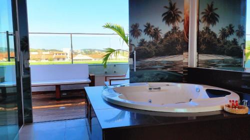 a large bath tub sitting on a counter in a bathroom at Paradiso Peró Praia Hotel in Cabo Frio