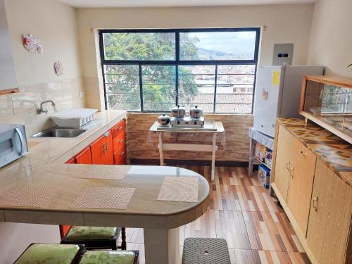Una cocina con una mesa y un fregadero y una ventana. en La Casa Quiteña, en Quito