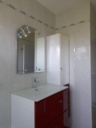 une salle de bain blanche avec un lavabo et un miroir dans l'établissement Villa Maite, quartier calme, piscine chauffée, à Andernos-les-Bains