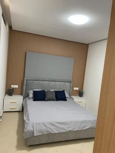 a bedroom with a large bed with blue pillows at 2 Bedroom flat Shengjin in Margjonaj