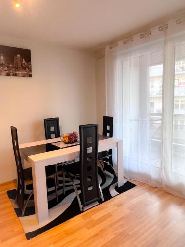 une salle à manger avec une table et des chaises blanches dans l'établissement Havre de paix 2-3 pièces, à Strasbourg