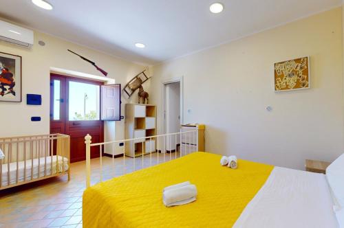 a bedroom with a yellow bed in a room at Casal Trinacria in Santa Teresa di Riva