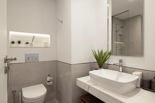 a white bathroom with a sink and a toilet at Spectacular 2BR Apartment Full BurjAlArab View in Dubai