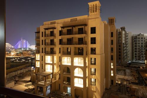 a tall building with lights on in a city at Spectacular 2BR Apartment Full BurjAlArab View in Dubai