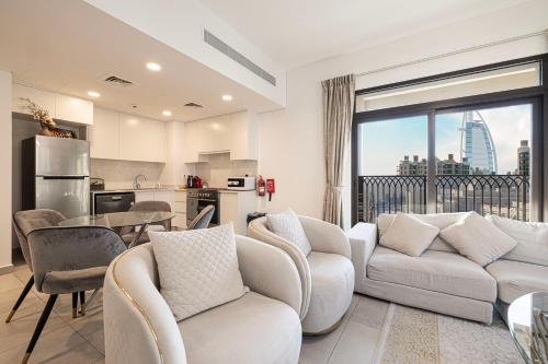 a living room with white furniture and a large window at Spectacular 2BR Apartment Full BurjAlArab View in Dubai