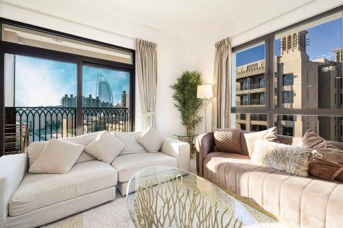 a living room with two couches and a large window at Spectacular 2BR Apartment Full BurjAlArab View in Dubai