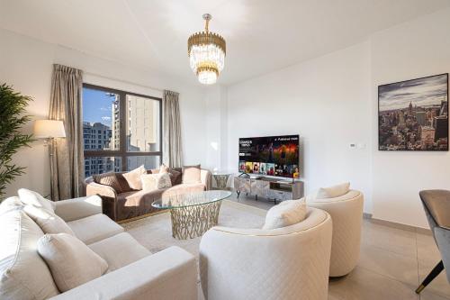 a living room with white furniture and a large window at Spectacular 2BR Apartment Full BurjAlArab View in Dubai