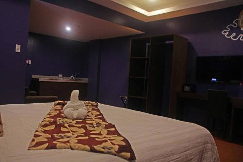 a bedroom with a bed with a stuffed animal on it at Hotel Palacio Puerto Princesa in Puerto Princesa City