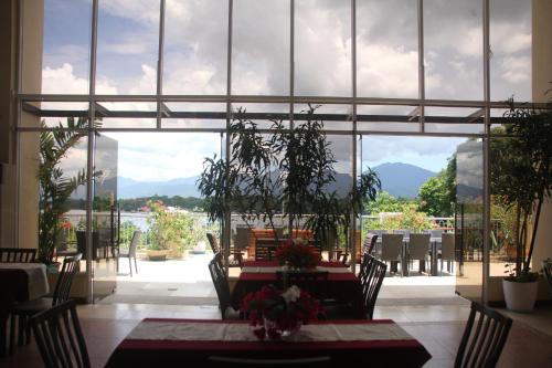 a dining room with a table and a large window at Hotel Palacio Puerto Princesa in Puerto Princesa City