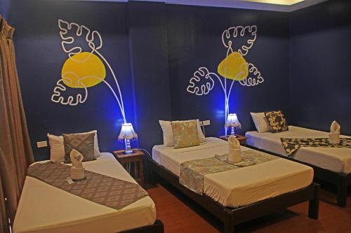 a room with two beds with lights on the wall at Hotel Palacio Puerto Princesa in Puerto Princesa City