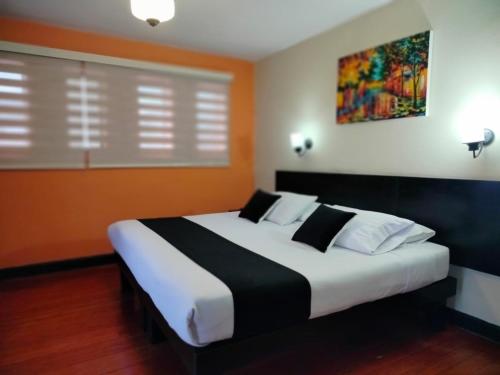 a bedroom with a large bed with white pillows at Hotel La Herreria Colonial in Popayan