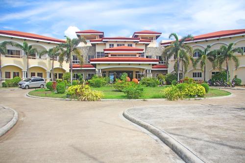 a large building with a car parked in front of it at Hotel Palacio Puerto Princesa in Puerto Princesa City