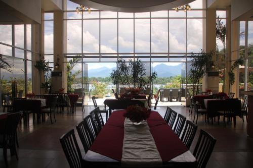 a dining room with a table and chairs and a large window at Hotel Palacio Puerto Princesa in Puerto Princesa City