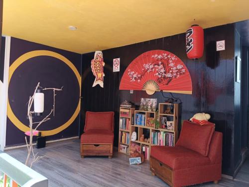 a room with two chairs and a book shelf at Casa Maguey in Mexico City