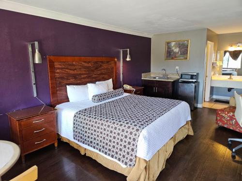 a hotel room with a bed and a sink at Fullerton Inn in Fullerton