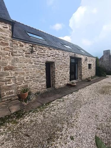 an old stone building with a window and a door at Gite L'escale in Pouldreuzic
