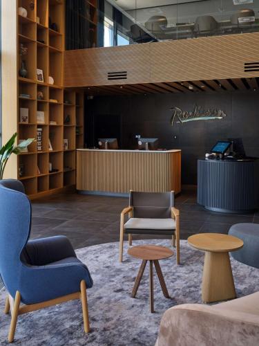 a waiting area with chairs and tables in a lobby at Radisson Hotel Budapest BudaPart in Budapest