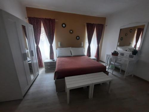 a bedroom with a bed and a table and windows at Viccinella House in Capranica