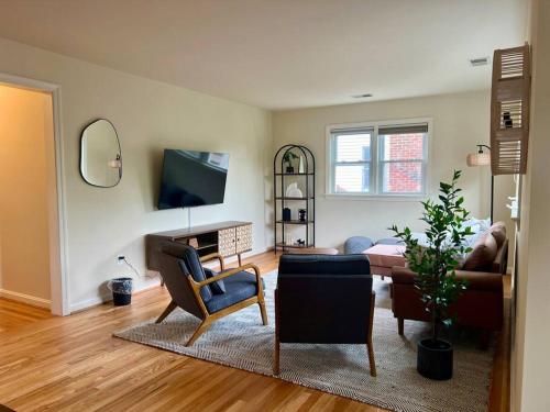 a living room with a couch and a tv at New Cozy Penthouse in Arlington