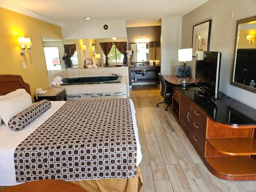 a hotel room with a bed and a bath tub at Fullerton Inn in Fullerton