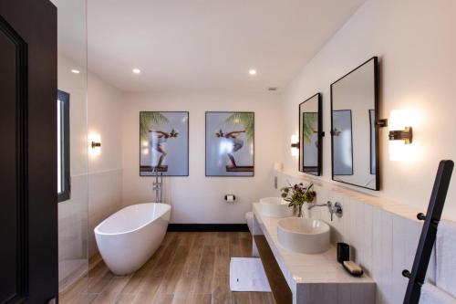 a bathroom with two sinks and two mirrors at Designers Delight 3 BR w Pool Gym Tennis Courts in Cupecoy
