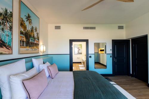 a bedroom with a large bed with pink pillows at Designers Delight 3 BR w Pool Gym Tennis Courts in Cupecoy