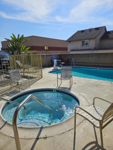 a hot tub with two chairs and a swimming pool at Fullerton Inn in Fullerton