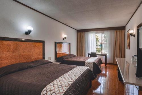 Postel nebo postele na pokoji v ubytování Hotel & Suites Villa del Sol