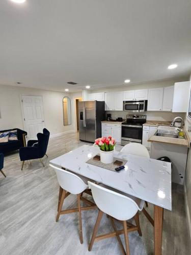 a kitchen with a white table and chairs and a table with flowers at Cozy Two Bedrooms Apartment in Valrico in Valrico