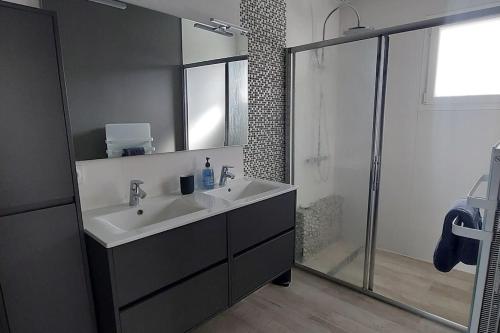 une salle de bain avec un lavabo et une douche dans l'établissement Villa Océan, environnement calme avec piscine chauffée 10 min de l'océan, à Le Porge