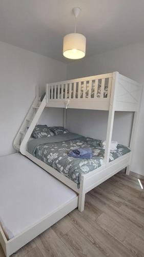 une chambre avec deux lits superposés dans une pièce dans l'établissement Villa Océan, environnement calme avec piscine chauffée 10 min de l'océan, à Le Porge