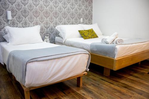 two beds sitting next to each other in a room at Hotel Bacata Plaza in Zipaquirá