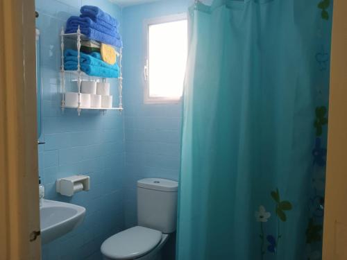 Un baño azul con inodoro y lavabo. en Apartamento acogedor en playa Gandía, en Playa de Gandía