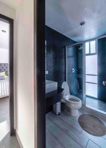 a bathroom with a toilet and a sink and a tub at Luxury Chapultepec Apartment in Guadalajara